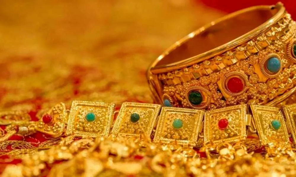 Gold marginally lower; silver gains