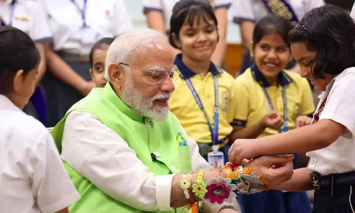 School children tie rakhis on Modi’s wrist